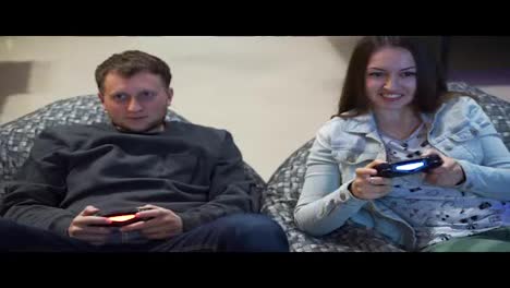 Young-couple-playing-video-game-at-home.-Shooting-and-controlling-using-the-game-controller