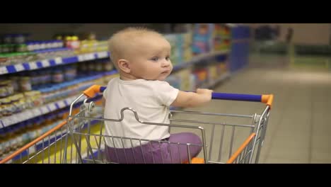 Kleines-Baby-Sitzt-In-Einem-Einkaufswagen-Im-Supermarkt-Und-Wartet-Darauf,-Dass-Seine-Mutter-Mit-Einkäufen-Zurückkommt.-Familieneinkauf-Mit