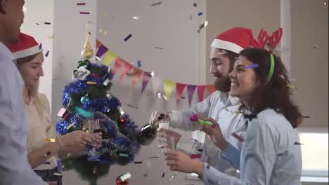 Young-african-office-worker-squibs-petard-with-confetti-while-group-of-young-people-is-celebrating-christmas-and-new-year-in-the