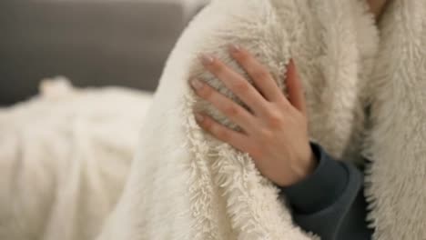 Female-hand-touching-the-fur-blanket-white-color