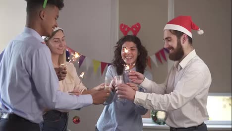 Group-of-young-people-toasting-for-achievements-in-New-Year-wearing-christmas-hats-and-deer-antler-headband-and-holding-Bengal