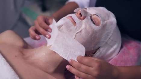 Close-Up-view-of-professional-cosmetologist-applying-special-mask-on-woman's-face-and-neck.-Professional-carboxytherapy-for-young