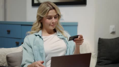 Blonde-woman-sitting-at-home-shopping-on-internet-store-using-laptop