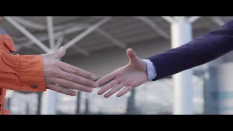 Professional-worker-shaking-hands-with-businessman-in-a-suit.-Close-Up-view