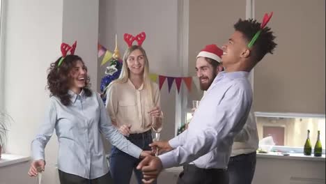 Having-fun-during-corporate-New-Year-party-in-the-office:-Multiracial-group-of-happy-office-workers-dancing-during-corporate-New