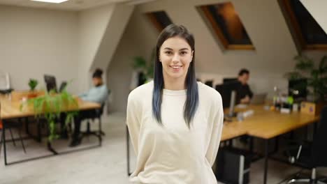 Smiling-modern-girl-standing-at-modern-office-coworking-space