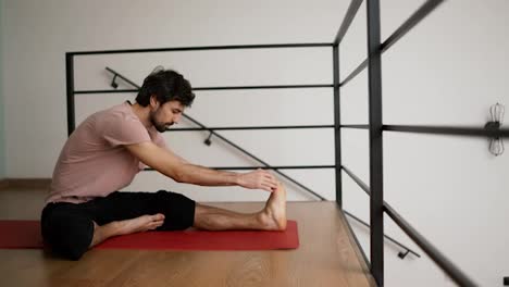 Man-stretching-at-home-floor
