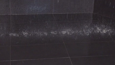 Water-drops-fall-at-the-black-tiled-floor