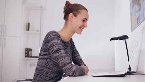 Glückliche-Lächelnde-Frau-Mit-Laptop-Computer,-Die-Zu-Hause-Oder-Im-Büro-Eine-Videokonferenz-Abhält.-Sie-Winkt-Mit-Der-Hand