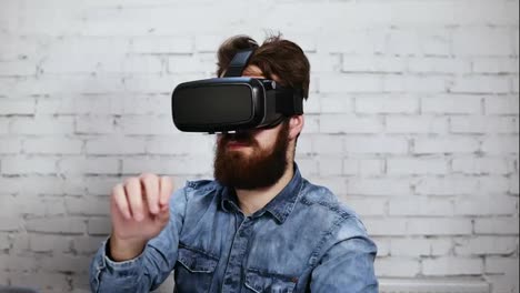 Man-wearing-virtual-reality-goggles-in-the-office.-He-is-working-using-virtual-reality.-Modern-technology-at-work