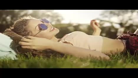 Trendy-hipster-girl-with-dreads-relaxing-on-the-grass-in-park.-Summer-lifestyle-portrait-of-hipster-woman-lying-on-the-grass