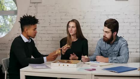Geschäftsteam-Aus-Jungen-Leuten,-Die-Gemeinsam-Pizza-Im-Büro-Genießen,-Millennials-Gruppe-Unterhält-Sich-Und-Hat-Spaß-Beim-Gemeinsamen-Mittagessen-In-Gemütlicher-Atmosphäre