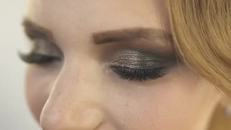 Close-Up-view-of-makeup-applied-on-eyes-of-a-model.-Model-with-false-eyelashes-opening-her-eyes-and-looking-in-the-camera