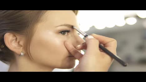 Makeup-artist-paints-the-eyebrows,-doing-eyebrow-correction.-Slow-Motion-shot