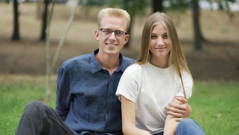 Portrait-of-a-young-beautiful-couple-on-a-picnic.-The-guy-hugs-the-girl.-happiness,-leisure
