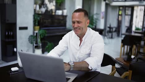 Smiling-businessman-working-on-laptop-computer-at-home-office.-Male-professional-typing-on-laptop-keyboard-at-office-workplace