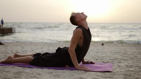 Ein-Junger-Mann-Praktiziert-Yoga-Und-Meditiert-Auf-Einer-Sportmatte,-Während-Er-Sich-Im-Morgengrauen-Hinlegt.-Eine-Bestimmte-Übung-Durchführen.-Meditation