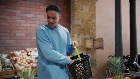 Young-attractive-mixed-race-man-choosing-products-in-the-supermarket,-putting-to-the-basket
