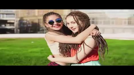 Two-happy-young-girls-with-dreads-hugging-each-other.-Excited-female-friends-embracing-each-other-and-laughing-during-the-sunny