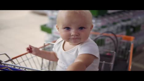 Kleines-Baby-Sitzt-In-Einem-Einkaufswagen-Im-Supermarkt-Und-Wartet-Darauf,-Dass-Seine-Eltern-Einkaufen.-Familieneinkauf-Mit-Ein-Wenig