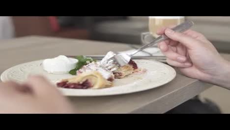 Unrecognizable-man-in-white-t-shirt-taking-desert-strudel-at-the-restaurant-using-fork-and-knife.-Slow-Motion-shot