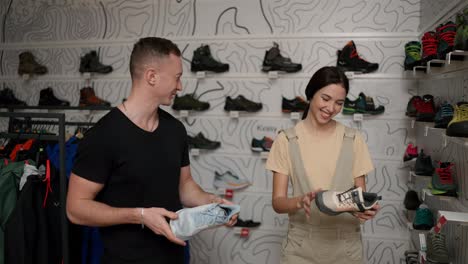 Couple-choosing-new-shoes-together,-woman-holds-new-sneakers
