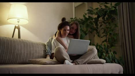 Happy-girls-friends-or-lesbians-using-laptop,-surfing-internet-together-at-home