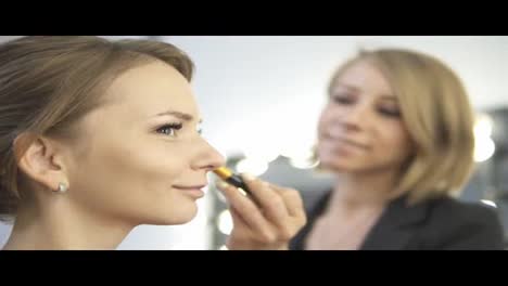 Make-up-Künstler-Trägt-Mit-Einem-Pinsel-Kosmetische-Grundierung-Und-Puder-Auf-Das-Gesicht-Auf.-Zeitlupenaufnahme