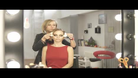 Makeup-artist-removing-white-patches-for-skin-protection-from-model's-skin.-Professional-makeup.-Slow-Motion-shot