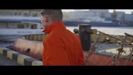 Harbor-Worker-in-orange-uniform-is-Walking-on-Cargo-Harbor-Site.-Slow-Motion