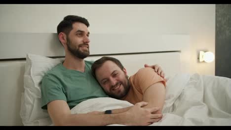 Glückliche-Homosexuelle-Männer,-Die-Sich-Morgens-Im-Bett-Umarmen