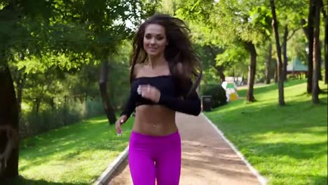 Happy-smiling-woman-in-sporty-bra-running-in-the-sunny-city-park-exercising-outdoors.-Steadicam-stabilized-shot,-Slow-Motion