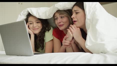 Drei-Beste-Freundinnen-Liegen-Im-Bett-Und-Schauen-Sich-Gemeinsam-Liebesgeschichten-Auf-Dem-Laptop-An