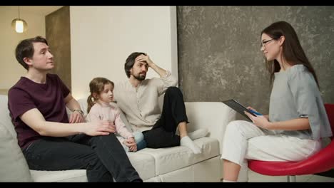 Sad-gay-couple-discussing-their-relationships-with-daughter-with-psychologist
