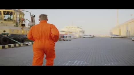 Arbeiter-In-Orangefarbener-Uniform-Läuft-Im-Hafen