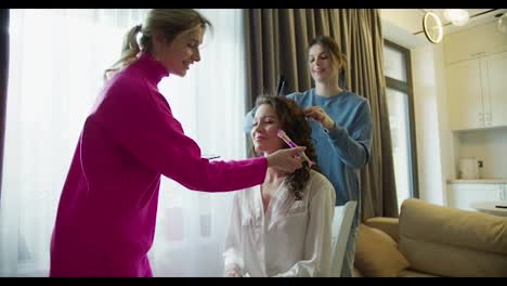 Beautiful-bridesmaids-are-getting-bride-ready-for-wedding-at-home