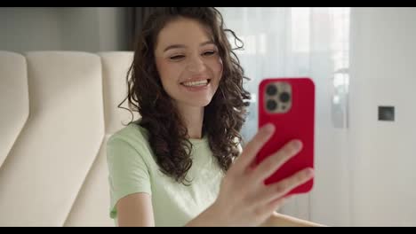 Brunette-woman-making-facetime-video-calling-with-smartphone-at-home