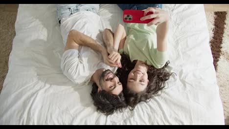 Junges-Paar-Liegt-Im-Bett-Und-Macht-Gemeinsam-Ein-Selfie