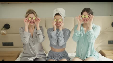 Pajama-party-concept---happy-friends-with-cucumber-mask-having-fun-doing-picaboo