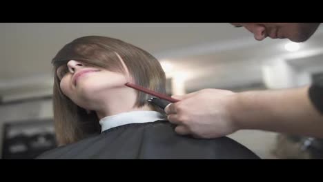 Close-Up-view-of-a-hairdresser's-hands-cutting-hair-with-scissors.-Hairdresser-at-work.-Beauty-salon.-shot-in-Slow-Motion