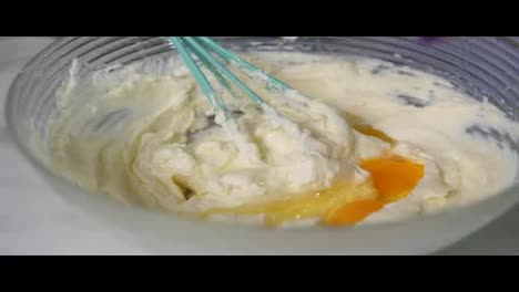 Close-Up-view-of-female-hands-preparing-dough-mixing-eggs-with-other-ingredients-using-whisk-in-the-kitchen.-Homemade-bakery