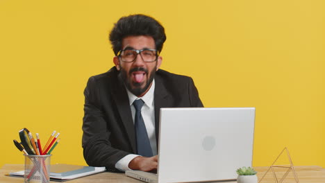 Office-businessman-hiding-behind-laptop-computer-making-funny-silly-face-fooling-around,-disrespect