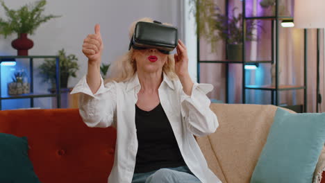 Senior-woman-use-virtual-reality-futuristic-technology-headset-play-simulation-3D-video-game-at-home