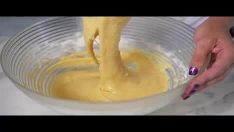 Close-Up-view-of-female-hands-mixing-ingredients-using-whisk-to-prepare-dough-in-the-kitchen.-Homemade-food.-Slow-Motion-shot