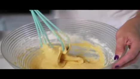 Close-Up-view-of-female-hands-preparing-dough-mixing-ingredients-using-whisk-in-the-kitchen.-Homemade-food.-Slow-Motion-shot