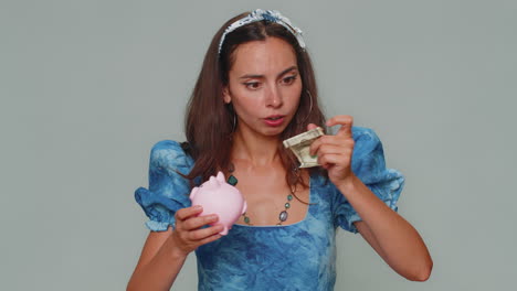 Poor-young-woman-holding-piggybank-and-one-dollar-banknote,-financial-crisis,-bankruptcy,-debt,-fail