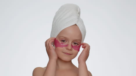 Smiling-child-girl-applying-pink-patches-under-eyes,-teenager-natural-skin-care,-perfect-fresh-clean
