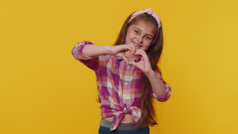 Smiling-preteen-child-girl-kid-makes-heart-gesture-demonstrates-love-sign-expresses-good-feelings