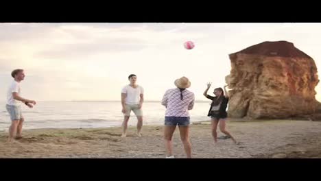 Joyful-young-friends-playing-volleyball-on-the-beach-by-the-sea-in-the-evening.-Active-vacation.-Slow-Motion-shot
