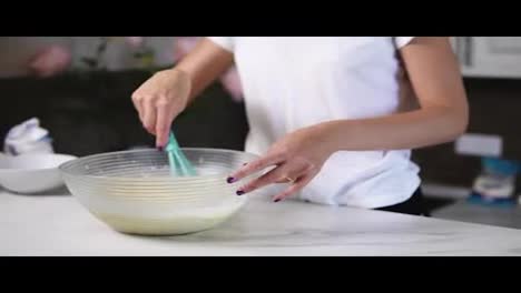 Unrecognizable-woman-prepares-dough-mixing-ingredients-in-the-the-bowl-using-whisk.-Homemade-food.-Slow-Motion-shot